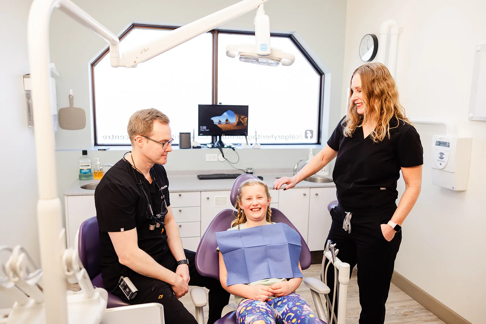 A child in the treatment chair with two Heritage Dental Centre team members