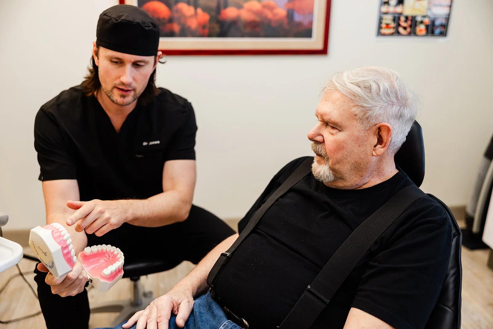 A dentist explaining a denture using a model